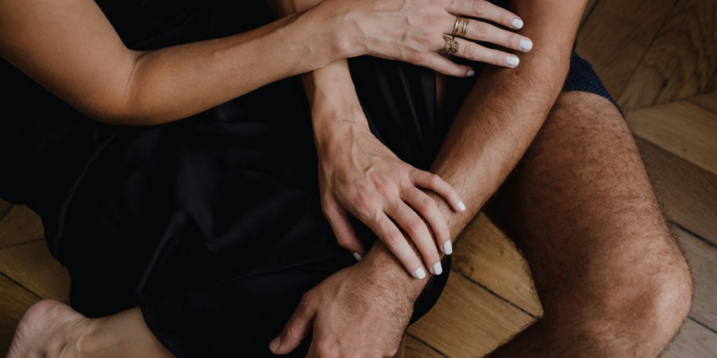 Bras d'un couple entrelacées, symbole d'intimité et de complicité - The Love Room