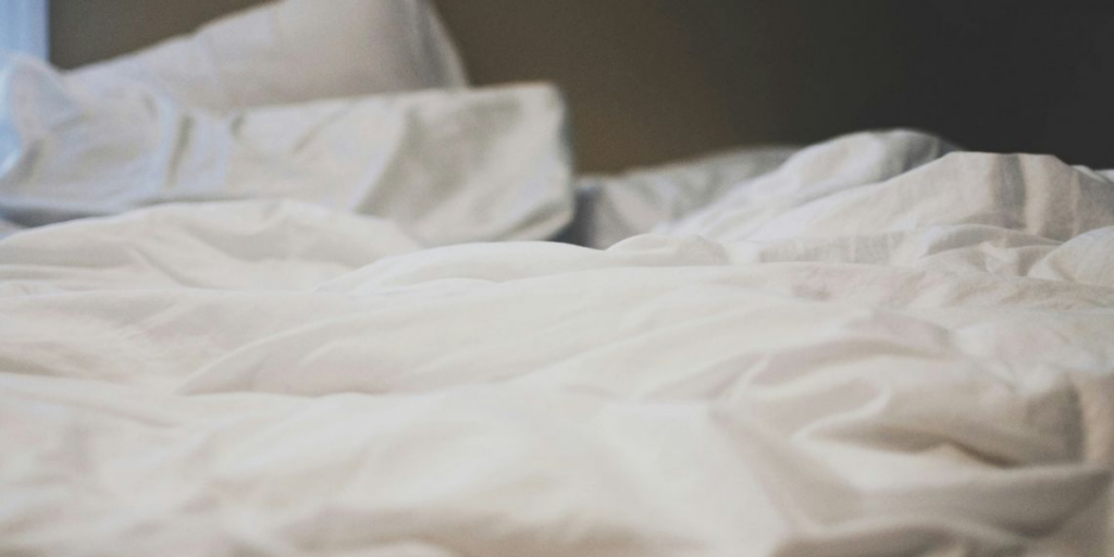 Draps blancs froissés évoquant une nuit passionnée - The Love Room